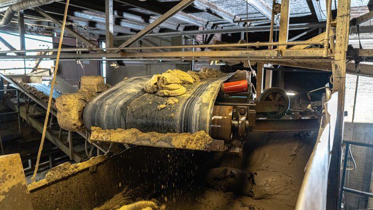 Steenfabriek Klinkers, klei uit de menger gaat door een zeef en wordt gemengd met restanten van reeds gemengde klei